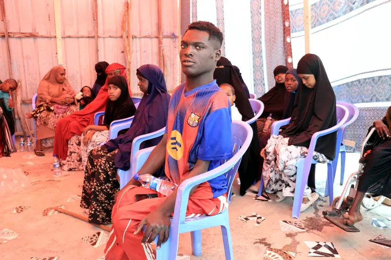 Young people and mothers seated in rows